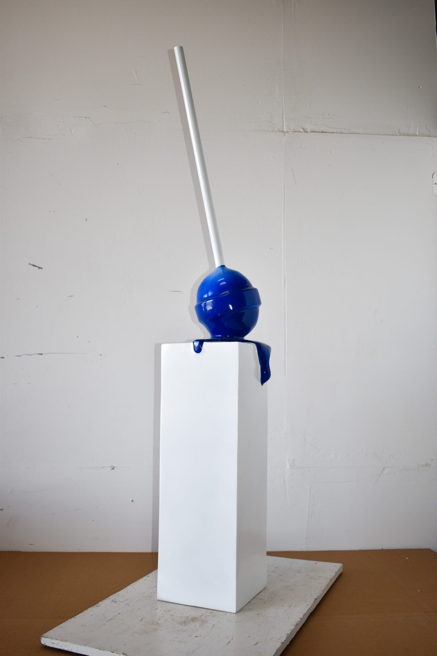 Blue Lollipop Mounted on A White Pedestal Resin Statue Size: 10" x 10" x 59"H