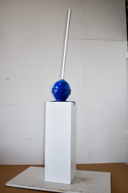 Blue Lollipop Mounted on A White Pedestal Resin Statue Size: 10" x 10" x 59"H