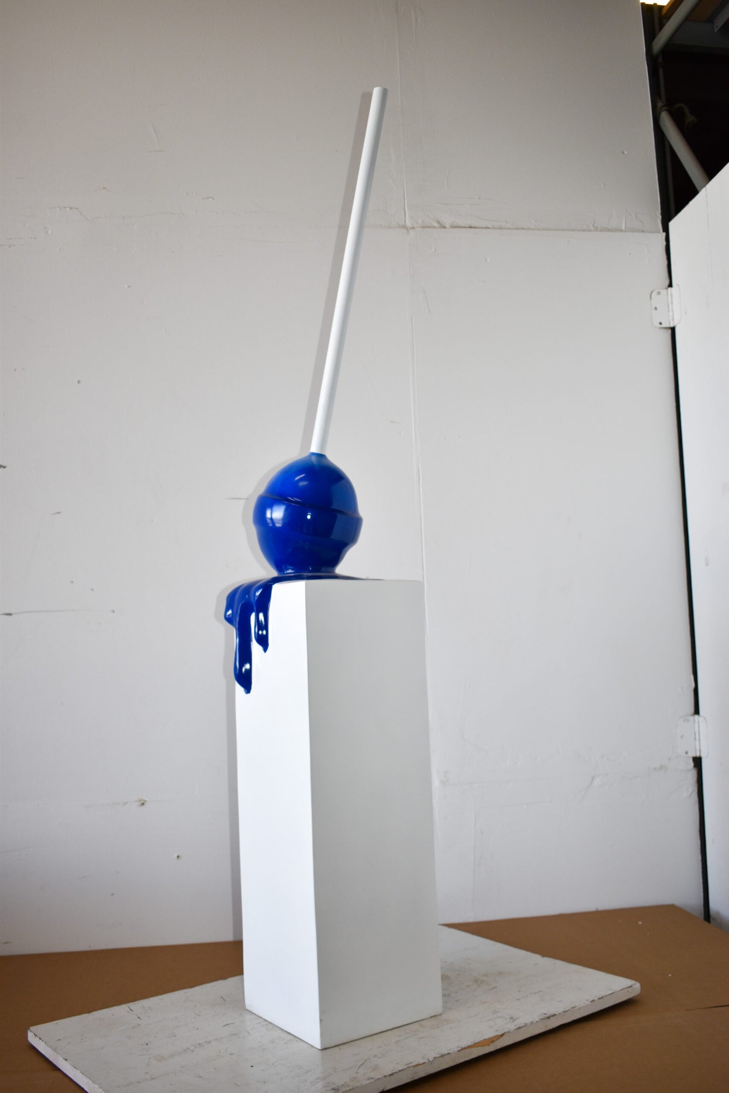 Blue Lollipop Mounted on A White Pedestal Resin Statue Size: 10" x 10" x 59"H