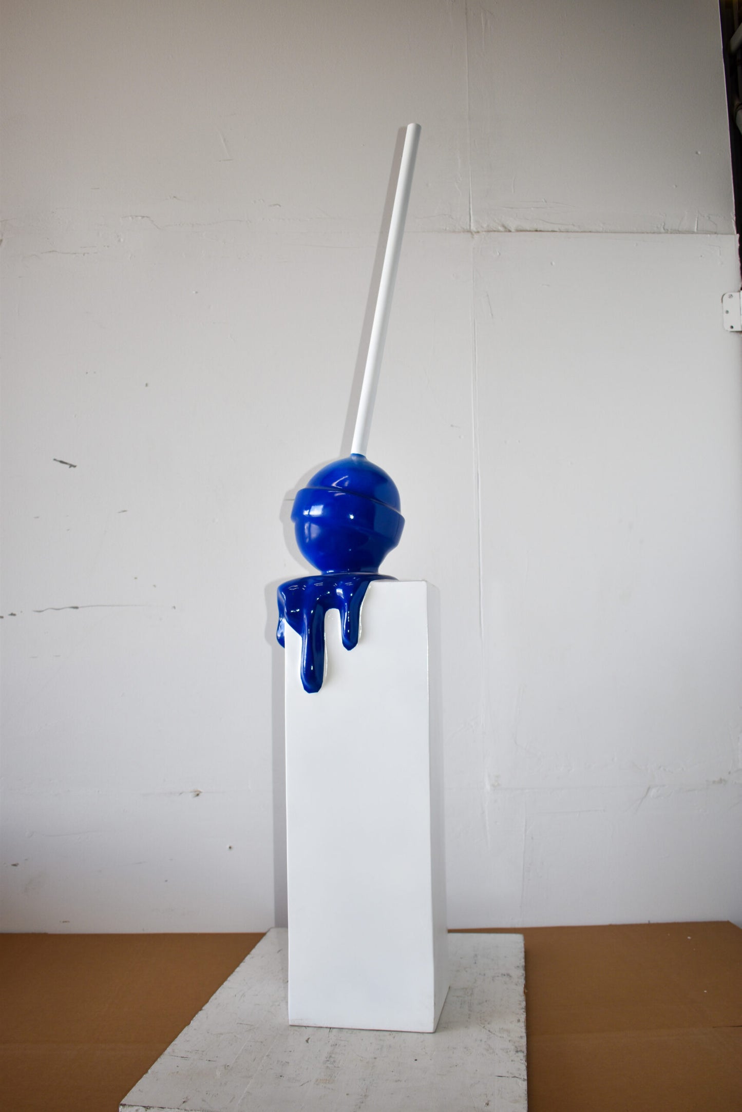 Blue Lollipop Mounted on A White Pedestal Resin Statue Size: 10" x 10" x 59"H