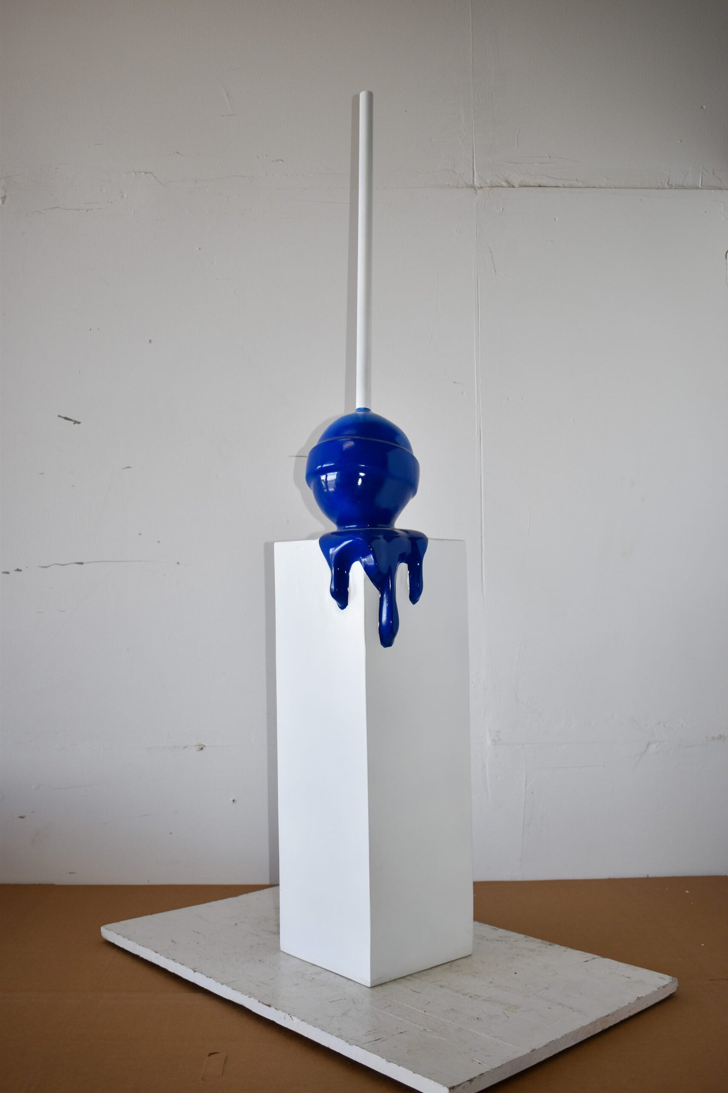 Blue Lollipop Mounted on A White Pedestal Resin Statue Size: 10" x 10" x 59"H