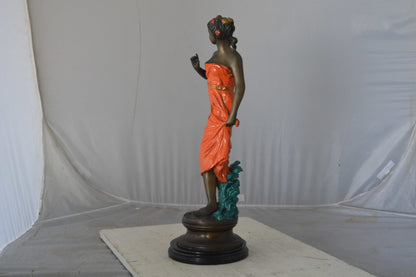 Young lady in orange bronze statue - Size: 7"L x 26"W x 25"H.