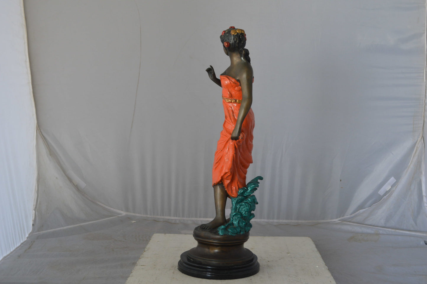 Young lady in orange bronze statue - Size: 7"L x 26"W x 25"H.