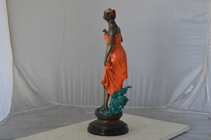 Young lady in orange bronze statue - Size: 7"L x 26"W x 25"H.