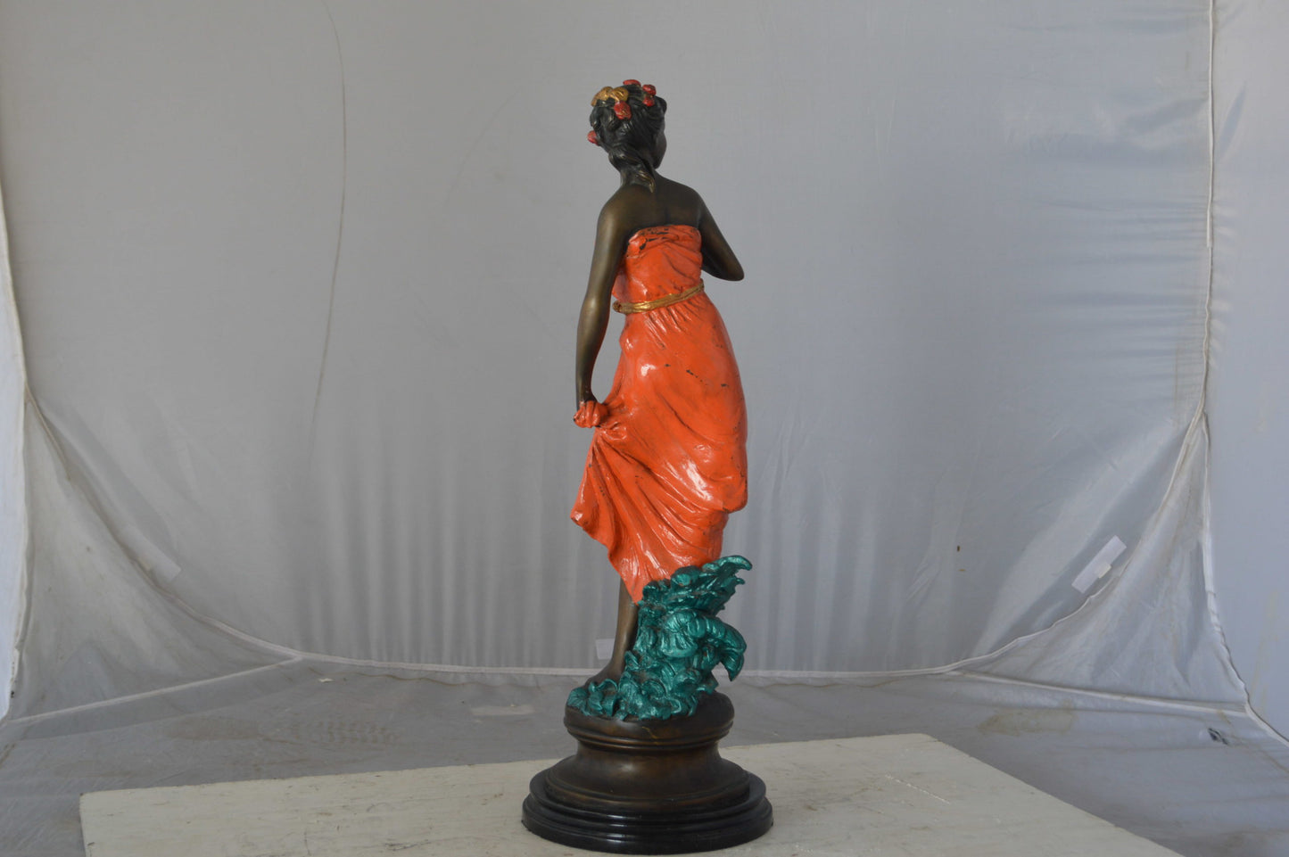 Young lady in orange bronze statue - Size: 7"L x 26"W x 25"H.