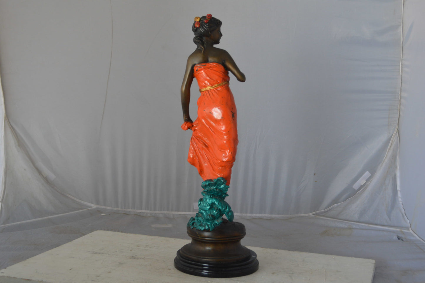 Young lady in orange bronze statue - Size: 7"L x 26"W x 25"H.