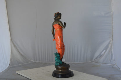 Young lady in orange bronze statue - Size: 7"L x 26"W x 25"H.