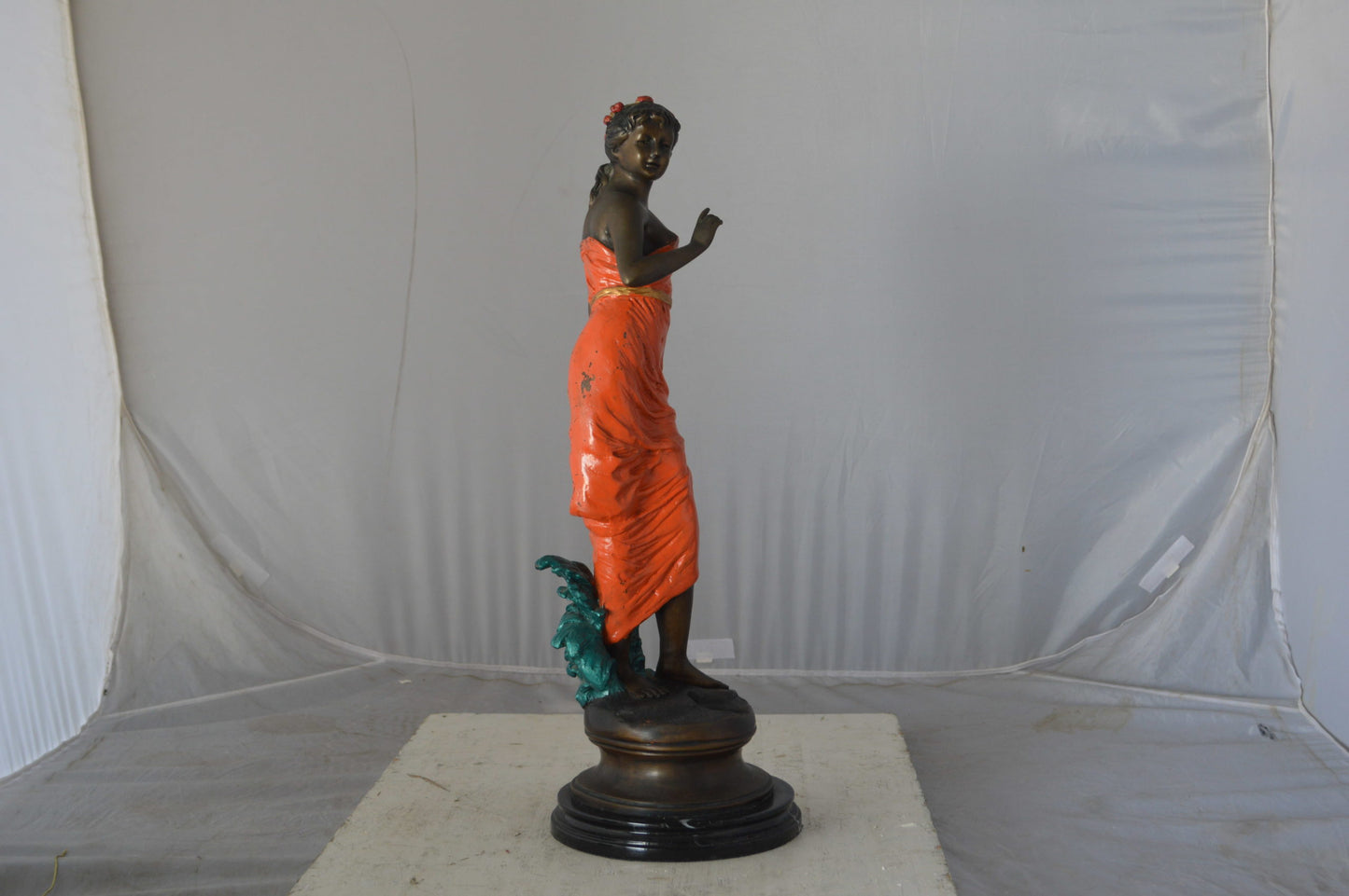 Young lady in orange bronze statue - Size: 7"L x 26"W x 25"H.