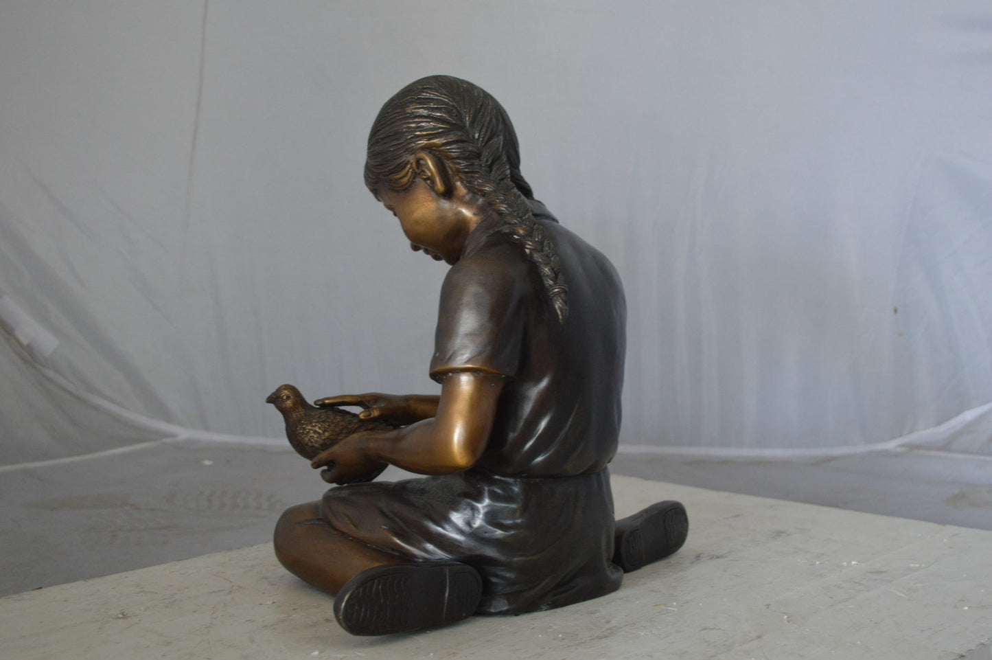 Young seated girl with bird bronze statue - Size: 12"L x 9"W x 14"H.