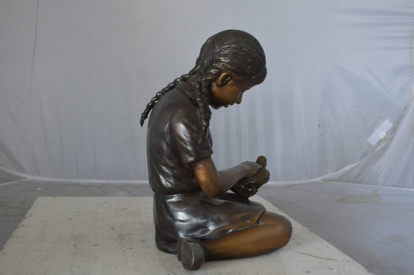 Young seated girl with bird bronze statue - Size: 12"L x 9"W x 14"H.