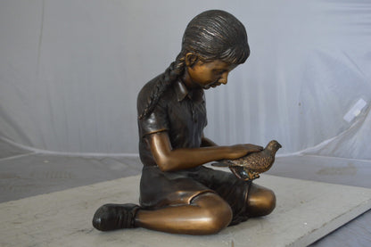 Young seated girl with bird bronze statue - Size: 12"L x 9"W x 14"H.