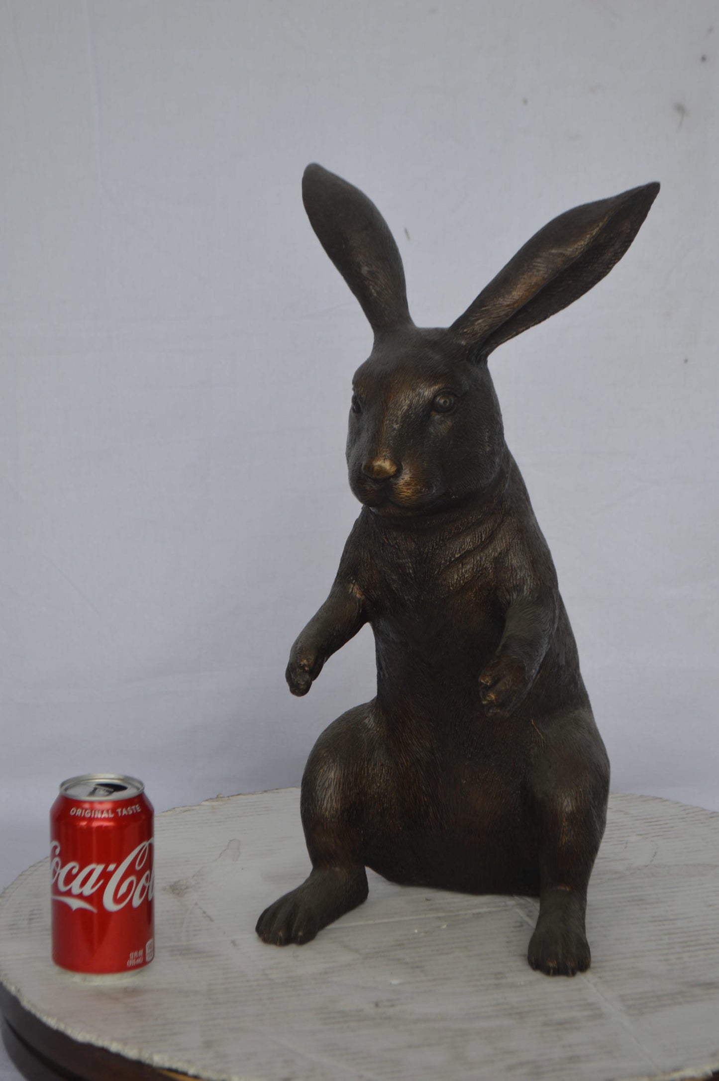 Rabbit looking down bronze statue - Size: 10"L x 12"W x 20"H.