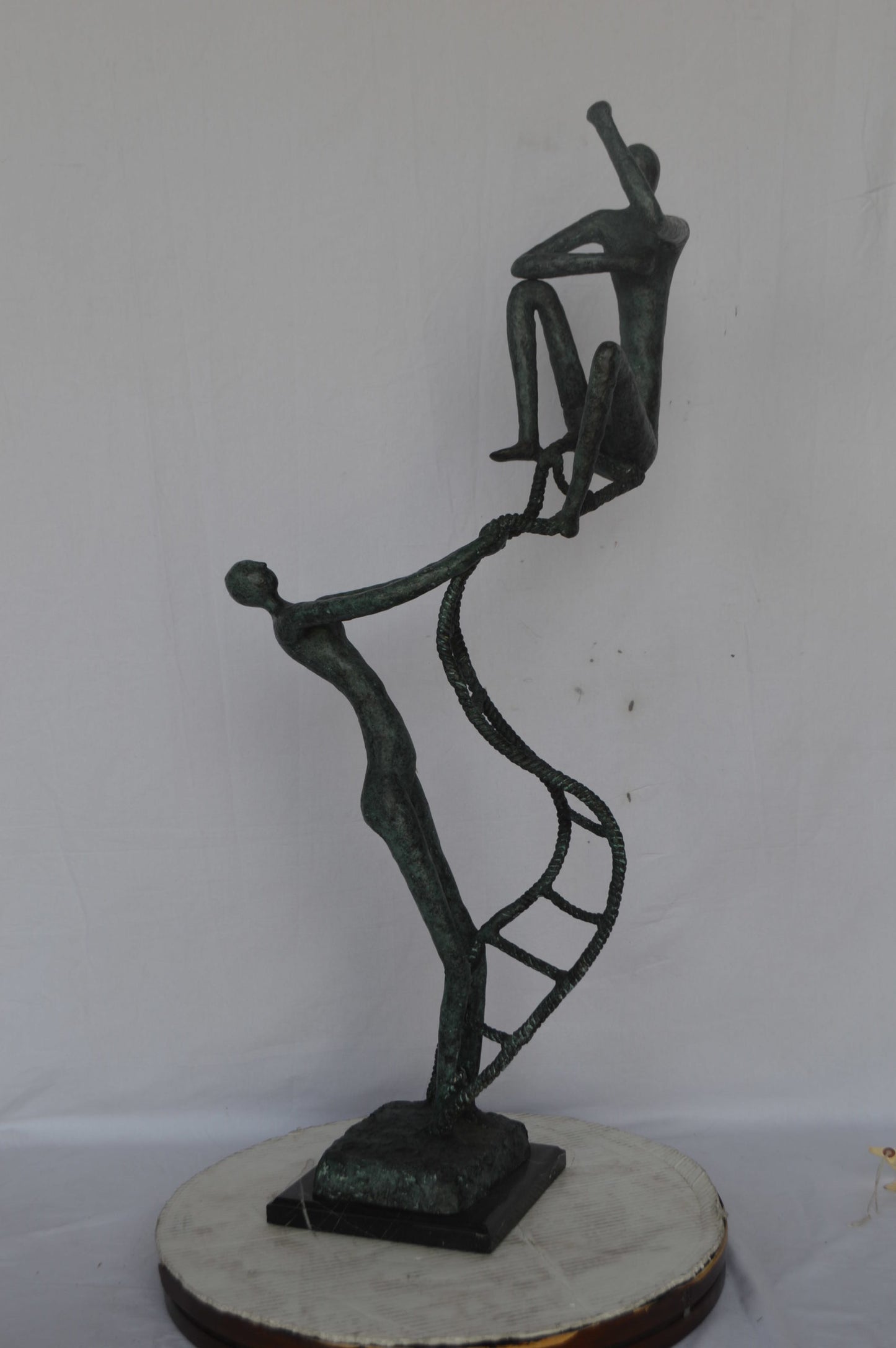 Modern art, two men climbing a latter bronze statue - Size: 14"L x 15"W x 47"H.