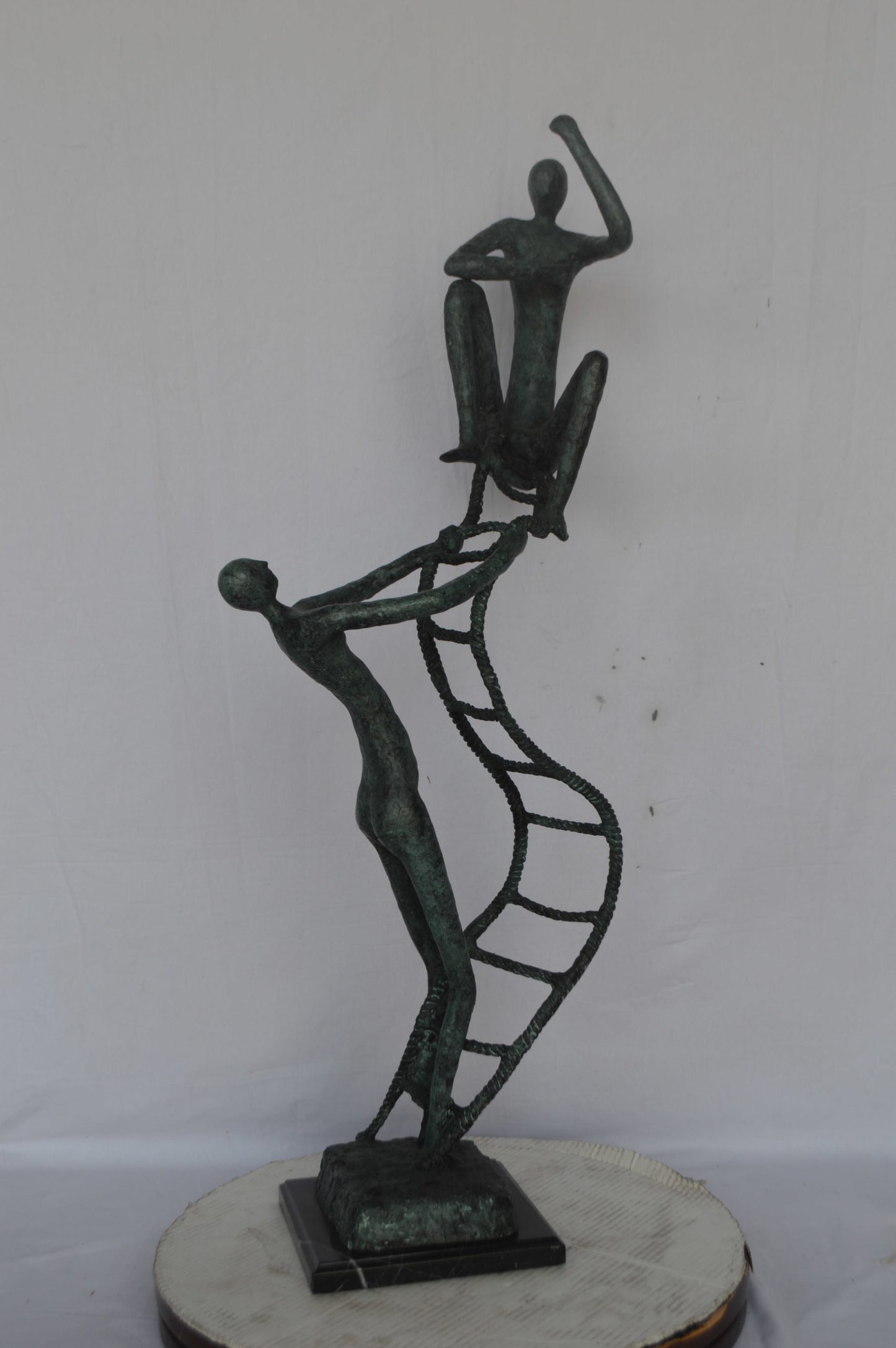 Modern art, two men climbing a latter bronze statue - Size: 14"L x 15"W x 47"H.