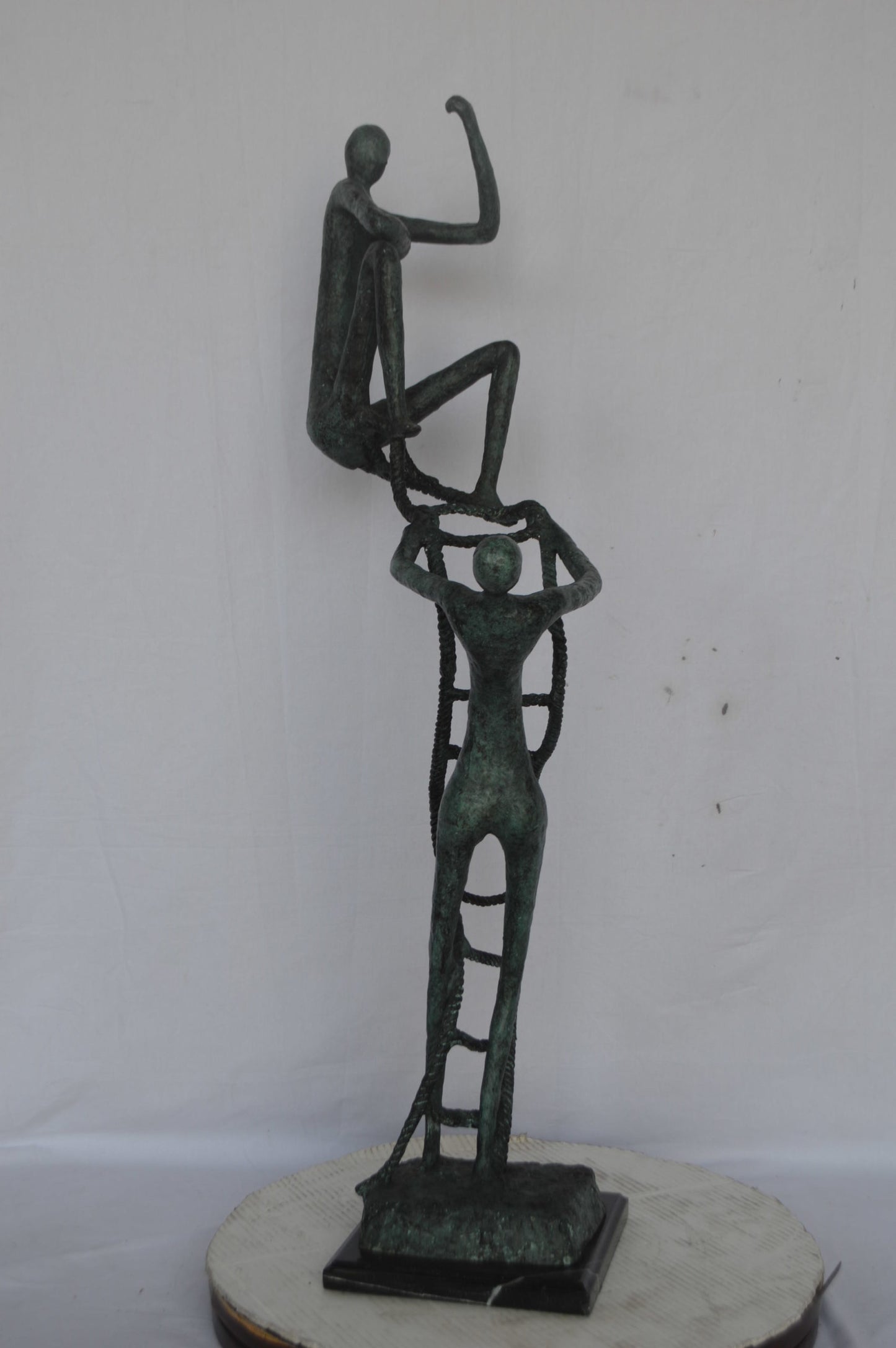 Modern art, two men climbing a latter bronze statue - Size: 14"L x 15"W x 47"H.