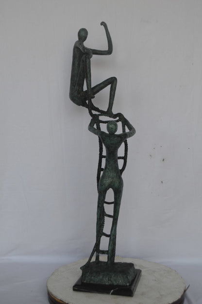 Modern art, two men climbing a latter bronze statue - Size: 14"L x 15"W x 47"H.