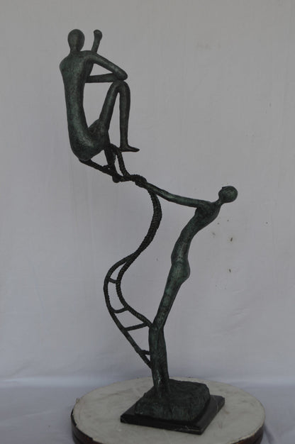 Modern art, two men climbing a latter bronze statue - Size: 14"L x 15"W x 47"H.