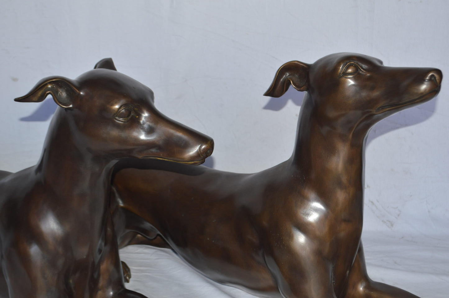 Pair of Greyhound dogs laying down Bronze Statues - Size: 50"L x 11"W x 20"H.