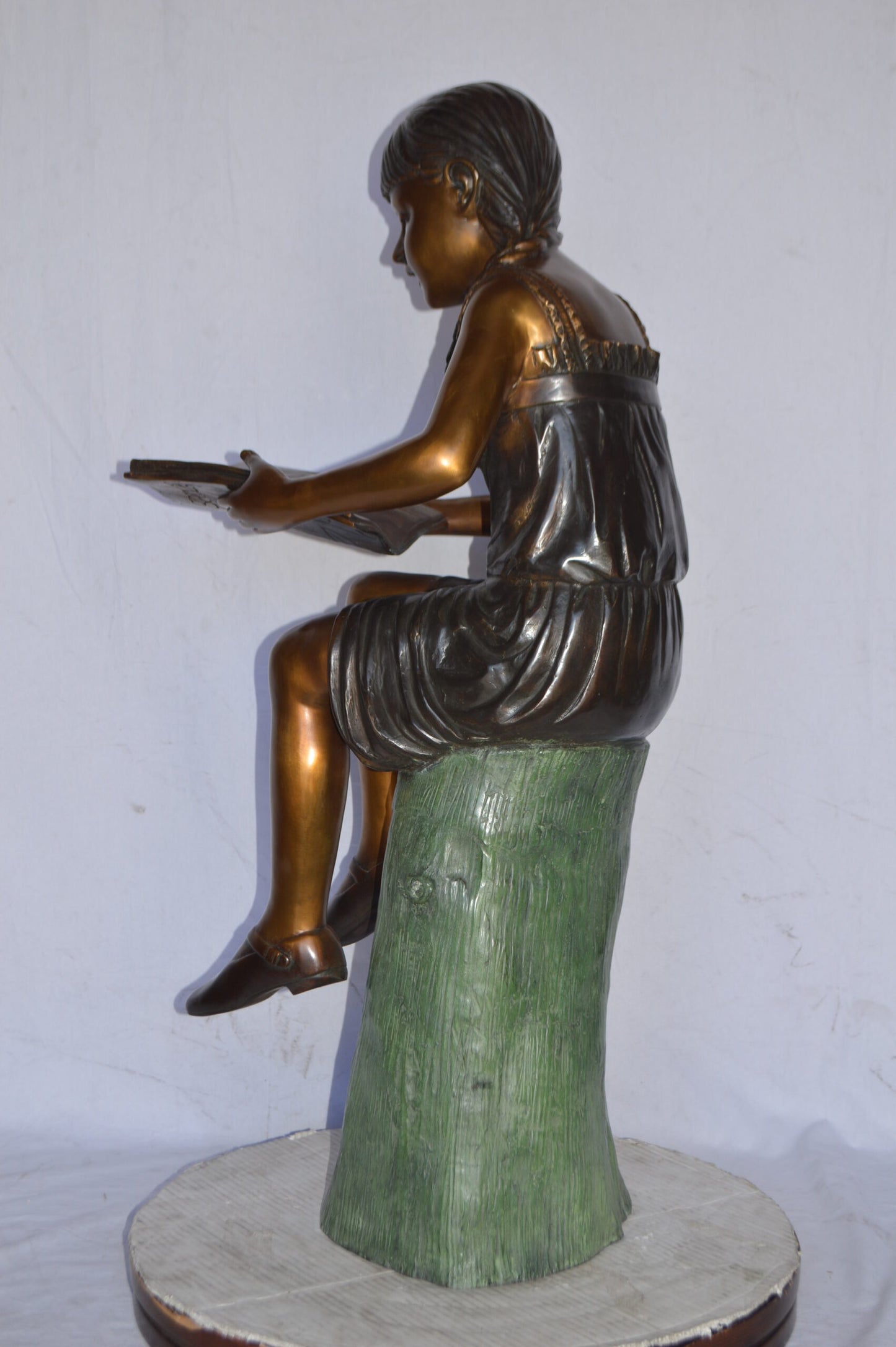 Girl Sitting on a Tree Stump, Reading Bronze Statue - Size: 15"L x 20"W x 22"H.