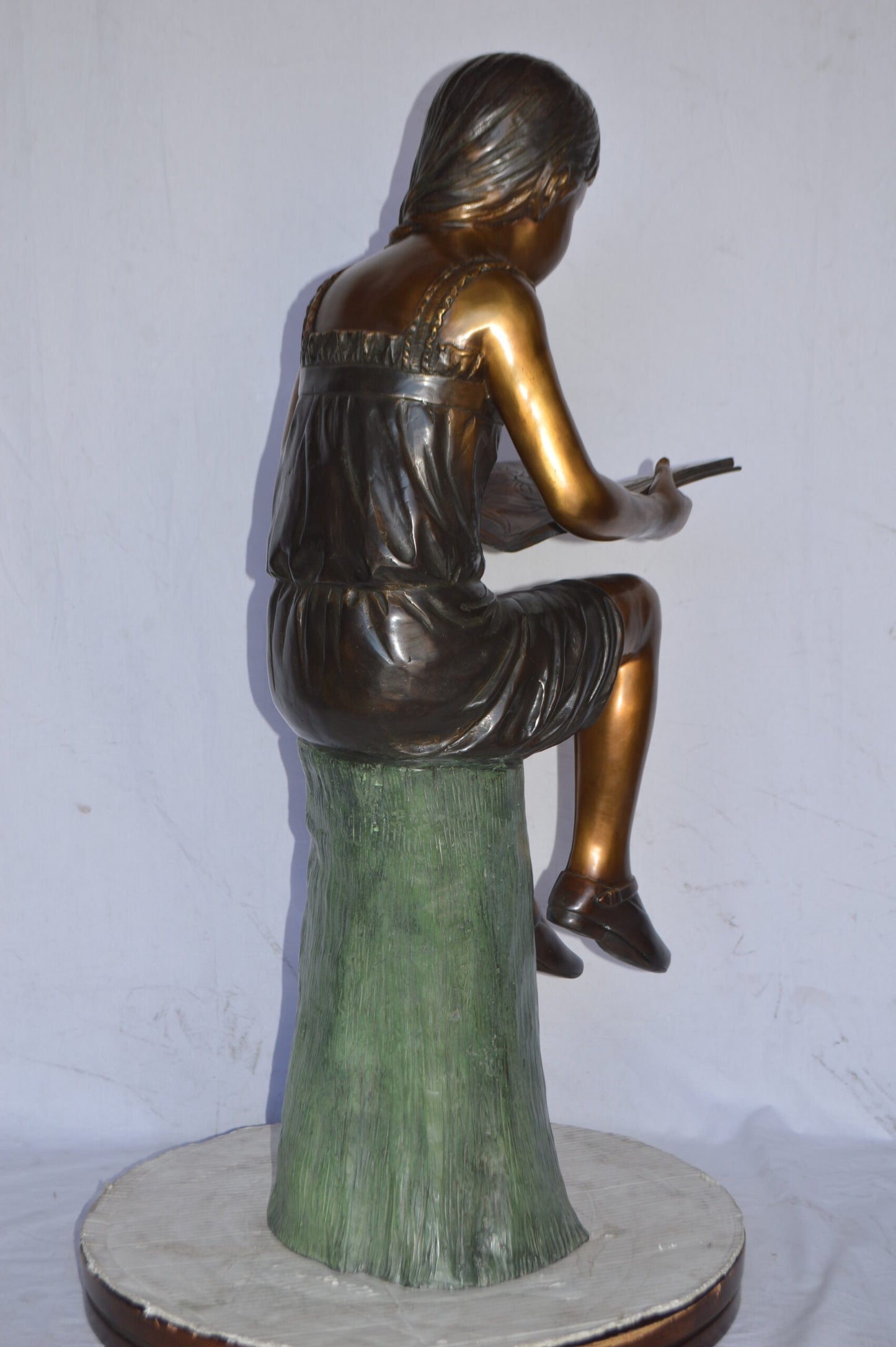 Girl Sitting on a Tree Stump, Reading Bronze Statue - Size: 15"L x 20"W x 22"H.