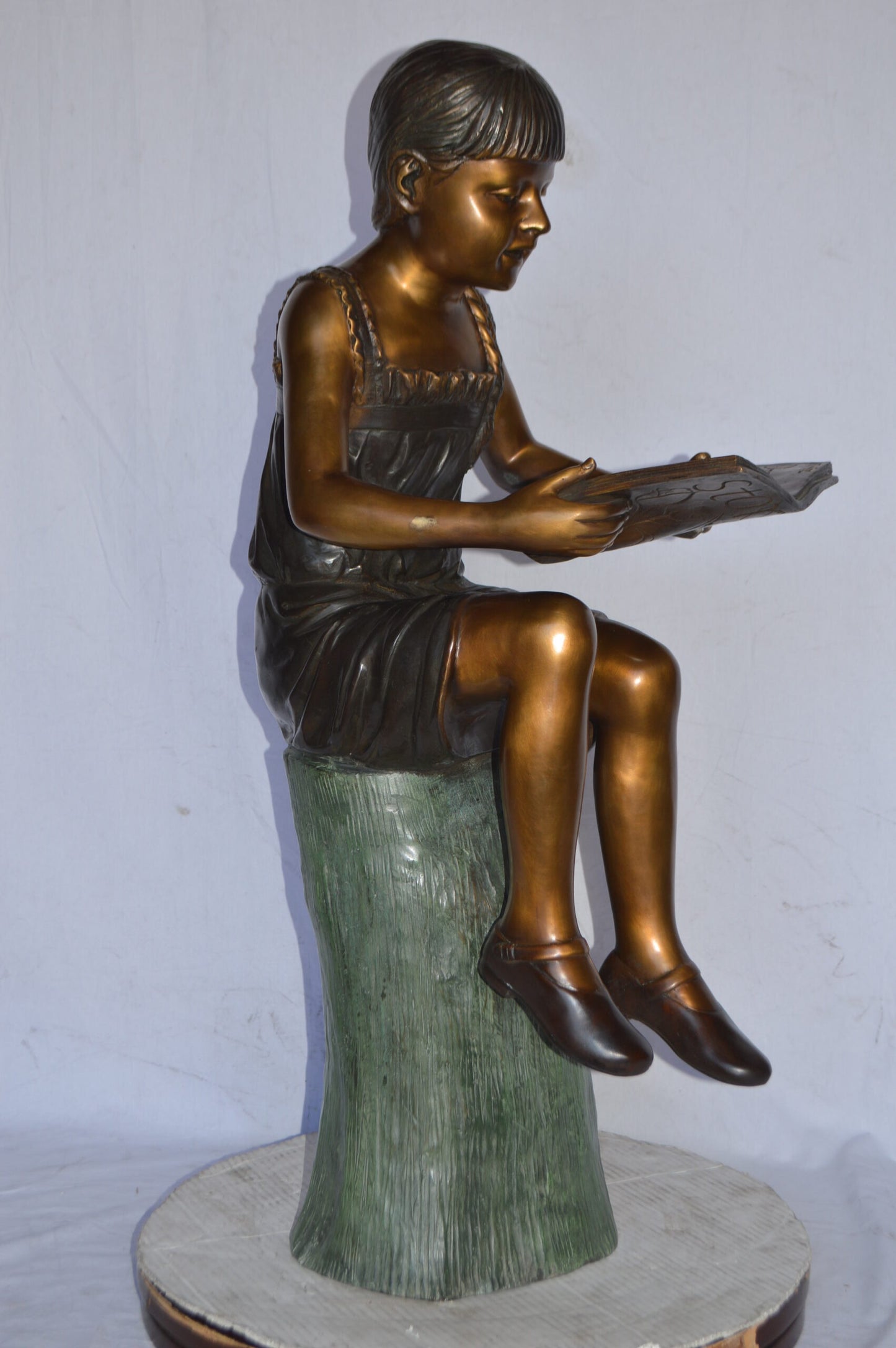 Girl Sitting on a Tree Stump, Reading Bronze Statue - Size: 15"L x 20"W x 22"H.
