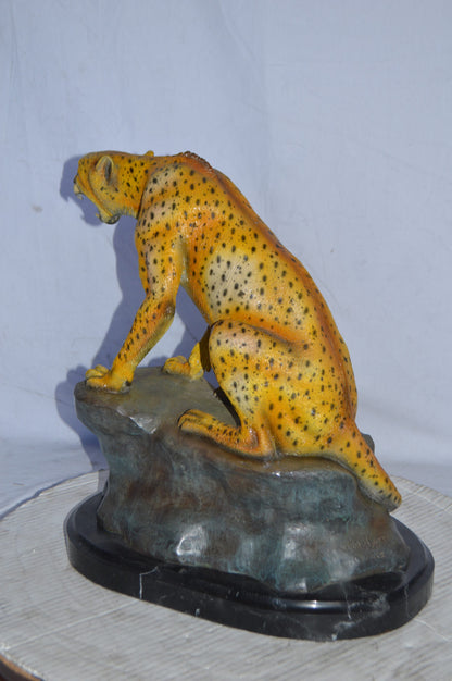 Cheetah sitting on a rock growling bronze statue - Size: 18"L x 12"W x 18"H.