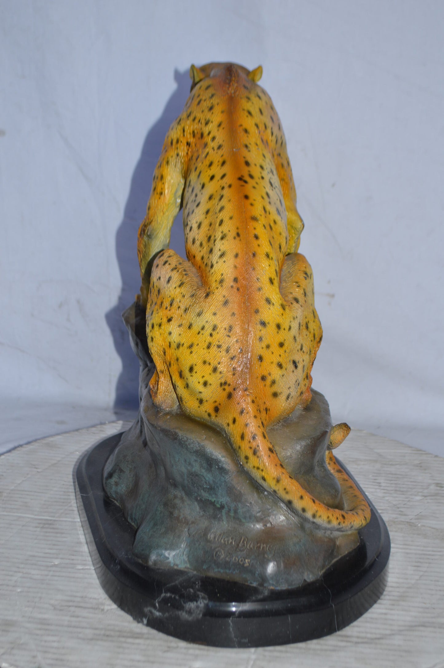 Cheetah sitting on a rock growling bronze statue - Size: 18"L x 12"W x 18"H.