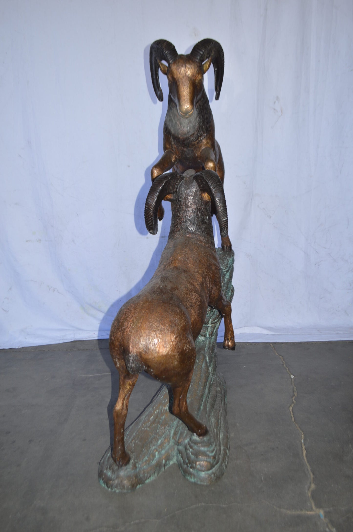 Two Life Size Rams on a rock Bronze Statue - Size: 49"L x 20"W x 64"H.