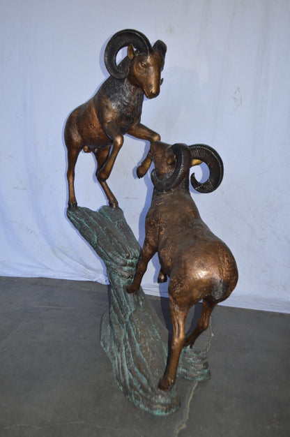 Two Life Size Rams on a rock Bronze Statue - Size: 49"L x 20"W x 64"H.