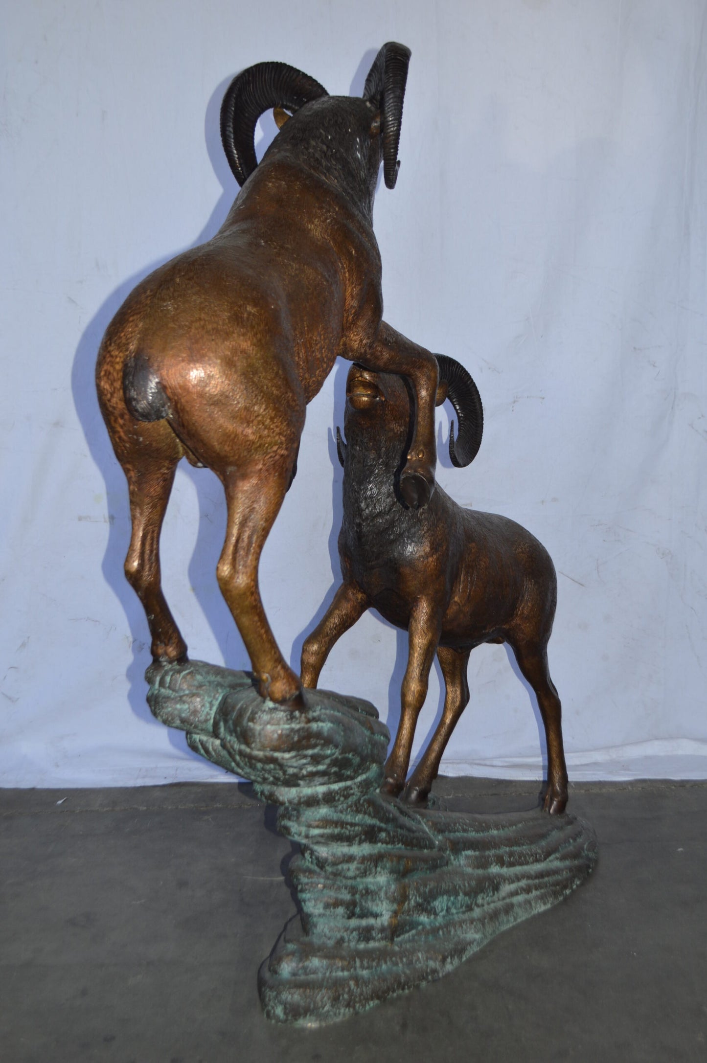 Two Life Size Rams on a rock Bronze Statue - Size: 49"L x 20"W x 64"H.