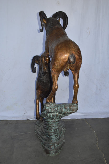 Two Life Size Rams on a rock Bronze Statue - Size: 49"L x 20"W x 64"H.