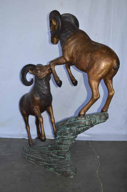 Two Life Size Rams on a rock Bronze Statue - Size: 49"L x 20"W x 64"H.