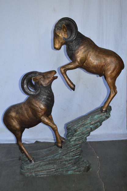 Two Life Size Rams on a rock Bronze Statue - Size: 49"L x 20"W x 64"H.