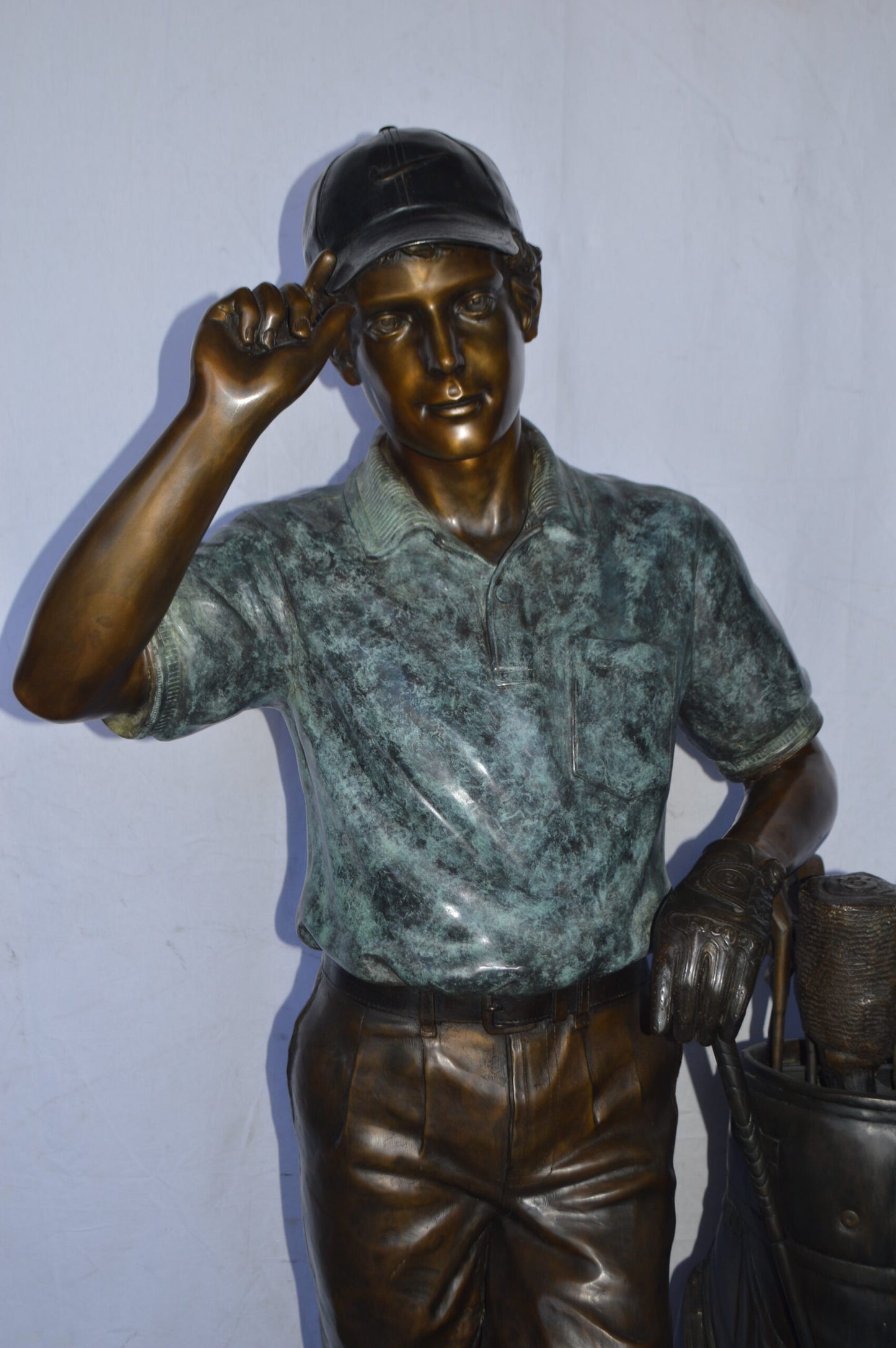 Golfer standing with his gear large bronze Statue - Size: 34"L x 21"W x 65"H.