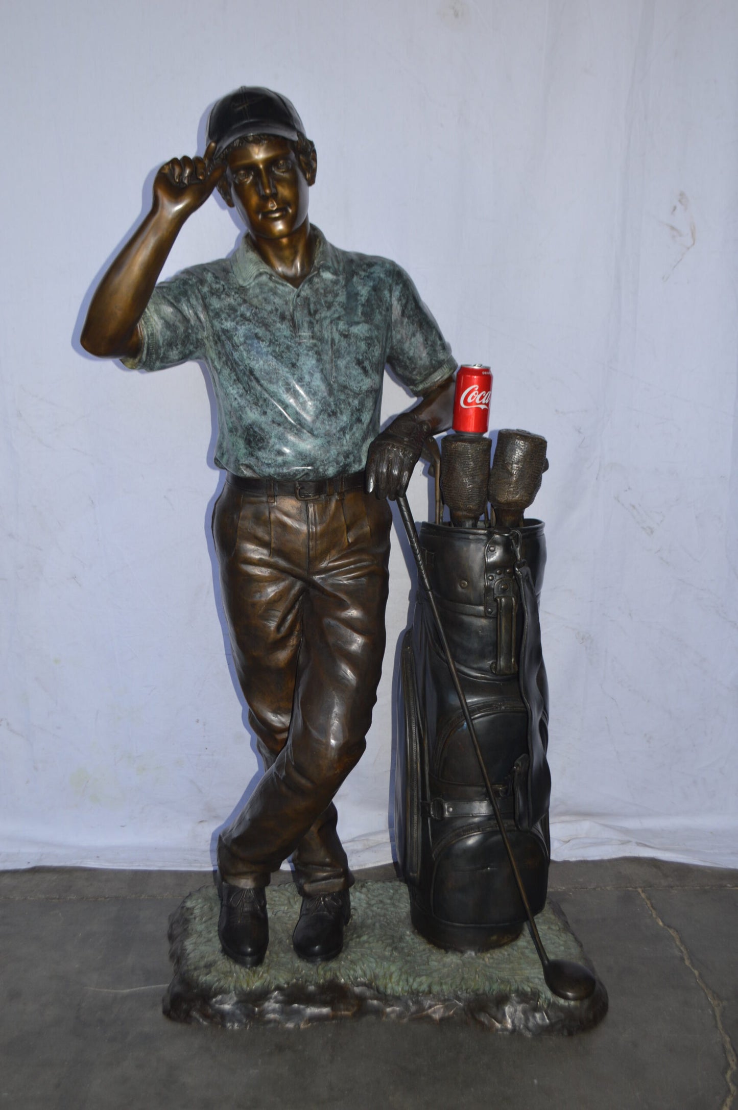 Golfer standing with his gear large bronze Statue - Size: 34"L x 21"W x 65"H.