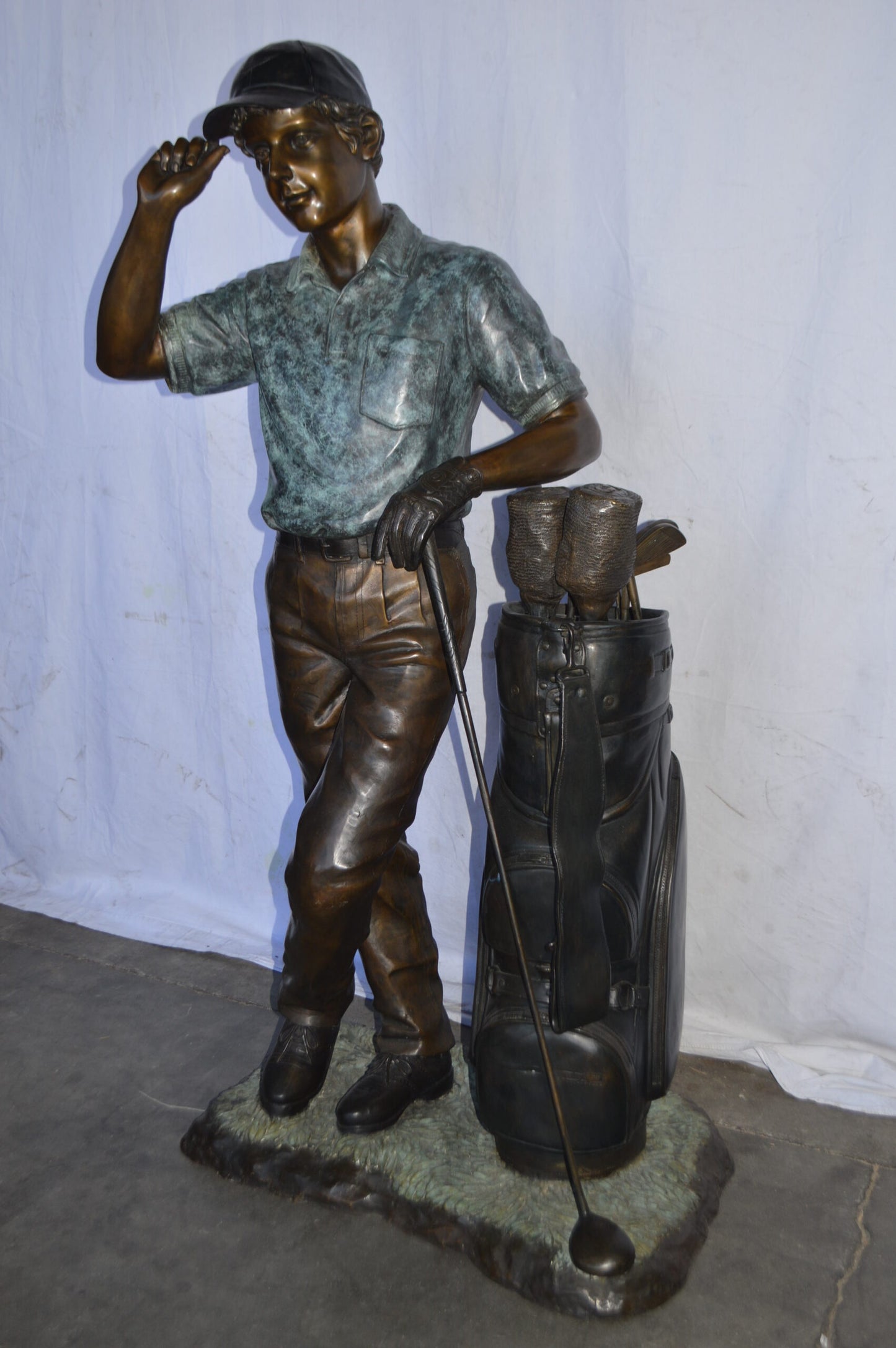 Golfer standing with his gear large bronze Statue - Size: 34"L x 21"W x 65"H.