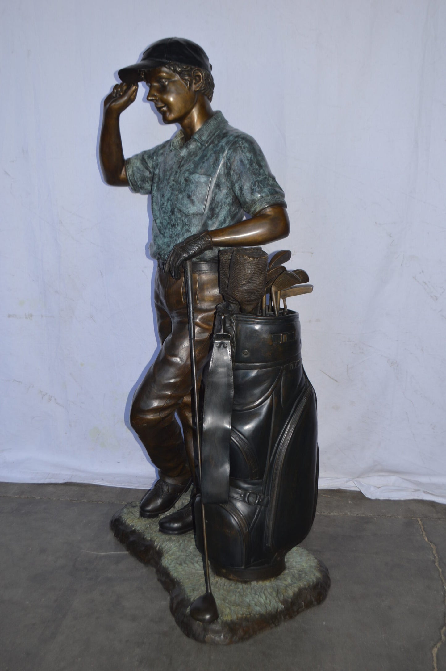 Golfer standing with his gear large bronze Statue - Size: 34"L x 21"W x 65"H.