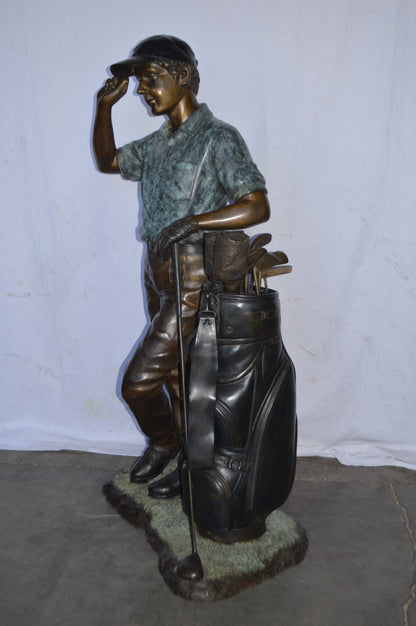 Golfer standing with his gear large bronze Statue - Size: 34"L x 21"W x 65"H.