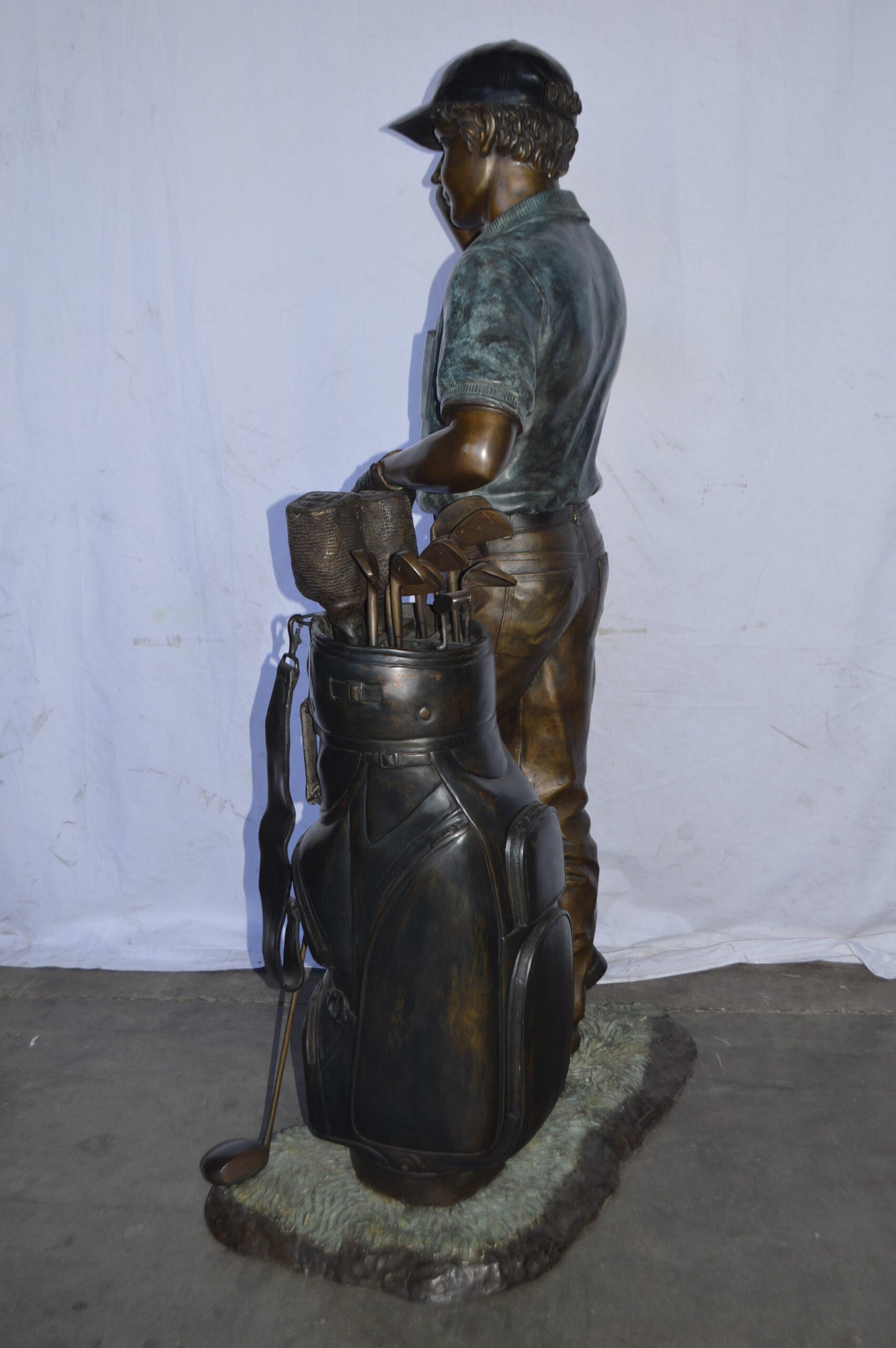 Golfer standing with his gear large bronze Statue - Size: 34"L x 21"W x 65"H.