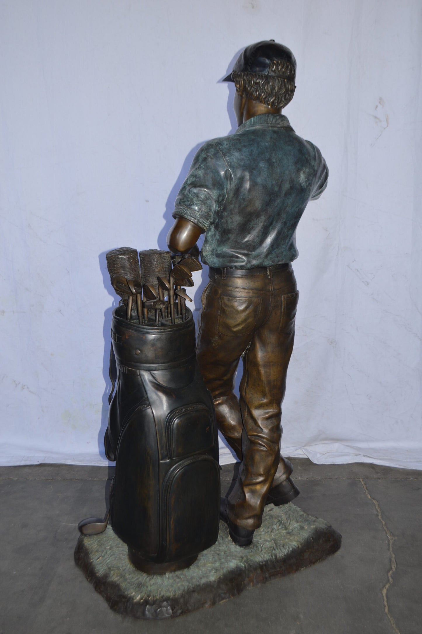 Golfer standing with his gear large bronze Statue - Size: 34"L x 21"W x 65"H.