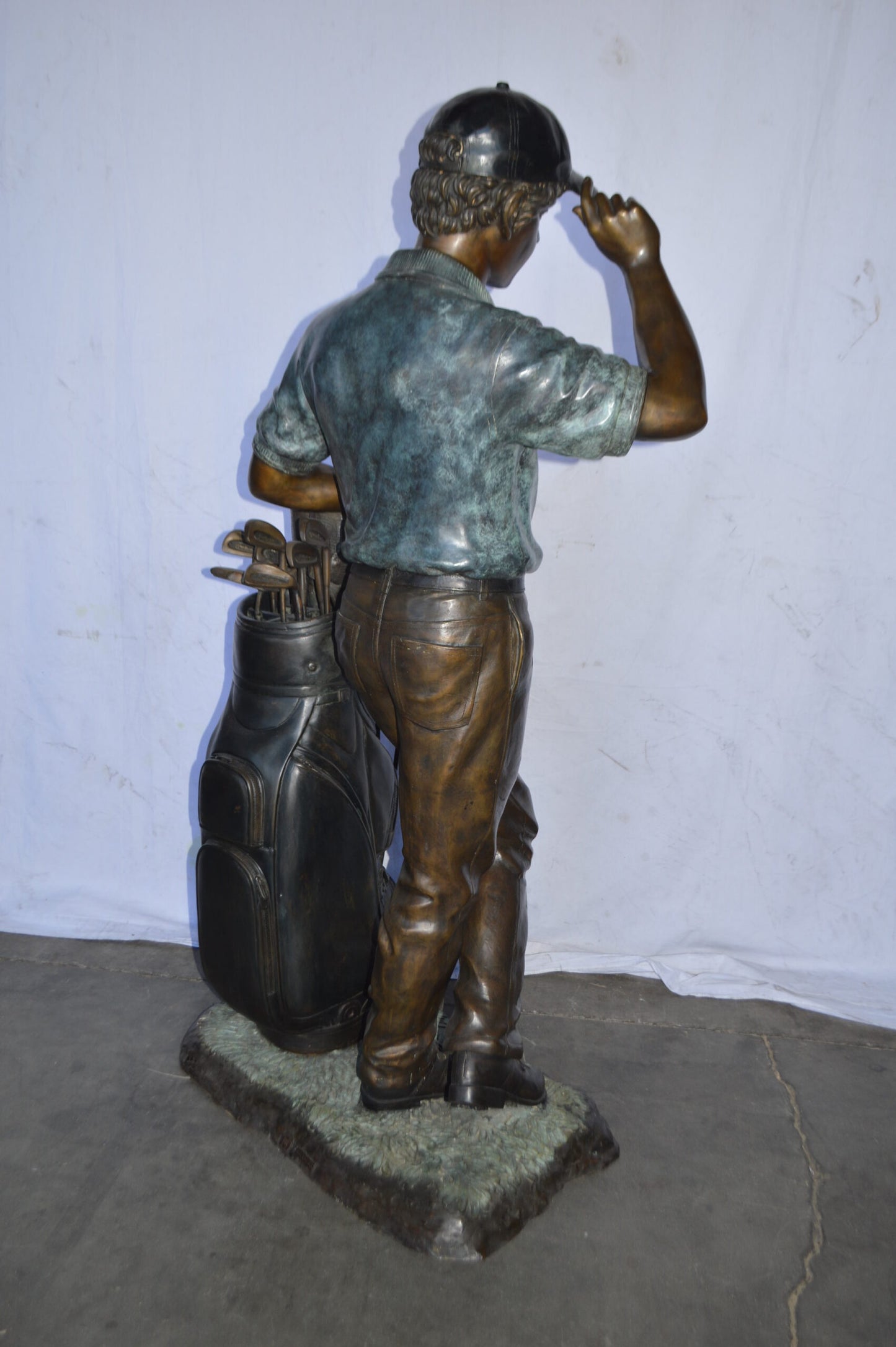 Golfer standing with his gear large bronze Statue - Size: 34"L x 21"W x 65"H.