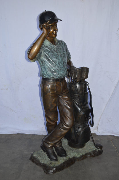 Golfer standing with his gear large bronze Statue - Size: 34"L x 21"W x 65"H.