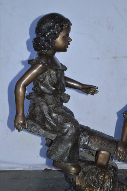 A Boy and a Girl Playing Seesaw Bronze Statue - Size: 17"L x 33"W x 36"H.