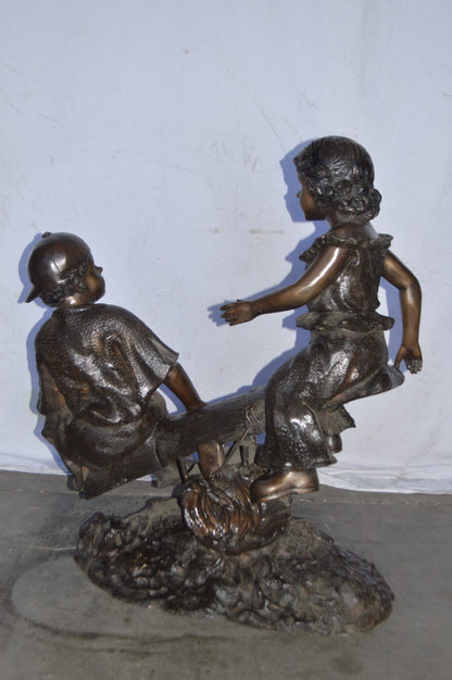 A Boy and a Girl Playing Seesaw Bronze Statue - Size: 17"L x 33"W x 36"H.