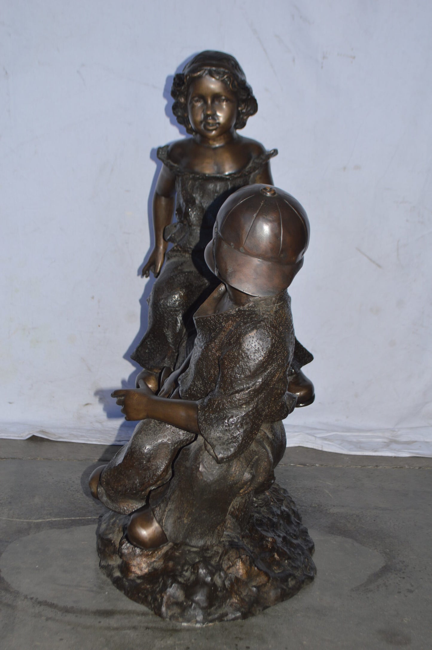 A Boy and a Girl Playing Seesaw Bronze Statue - Size: 17"L x 33"W x 36"H.