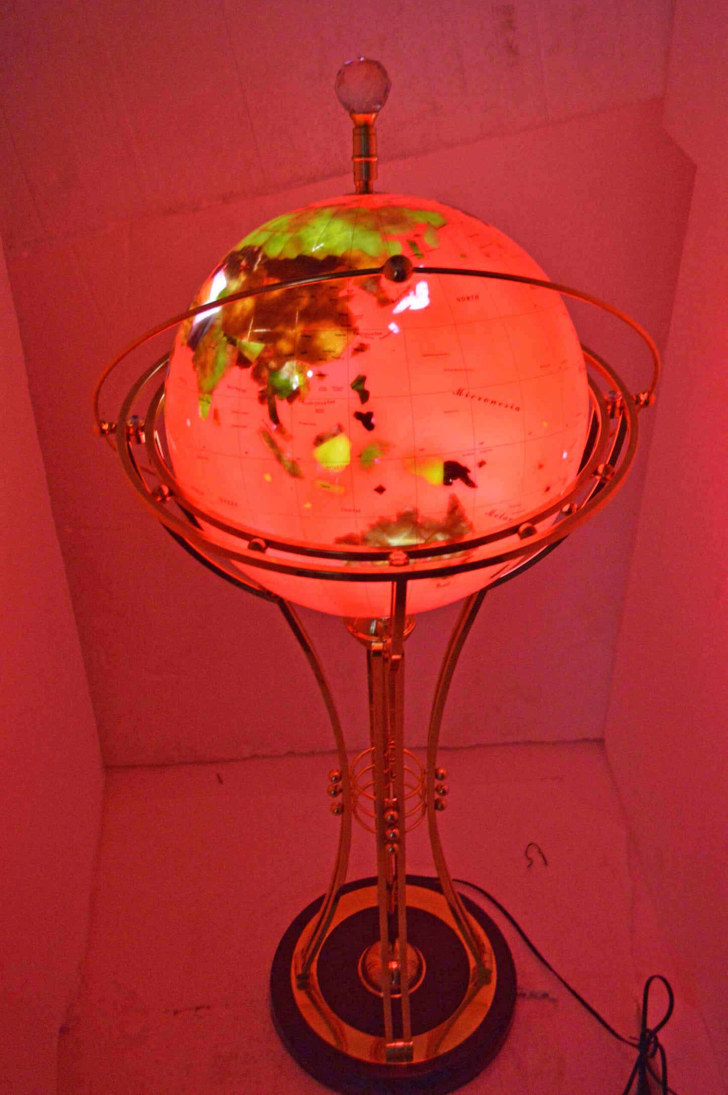 Illuminated Red - Gold World Globe Rotated by motor - Size: 19"L x 19"W x 42"H.