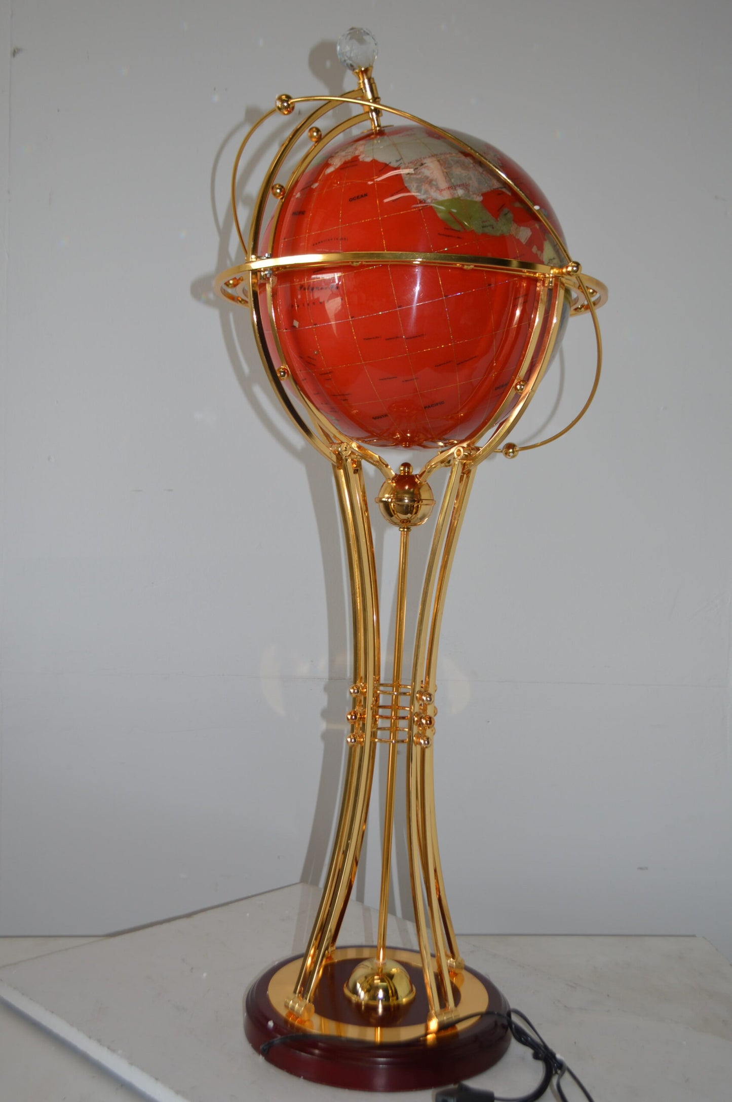 Illuminated Red - Gold World Globe Rotated by motor - Size: 19"L x 19"W x 42"H.