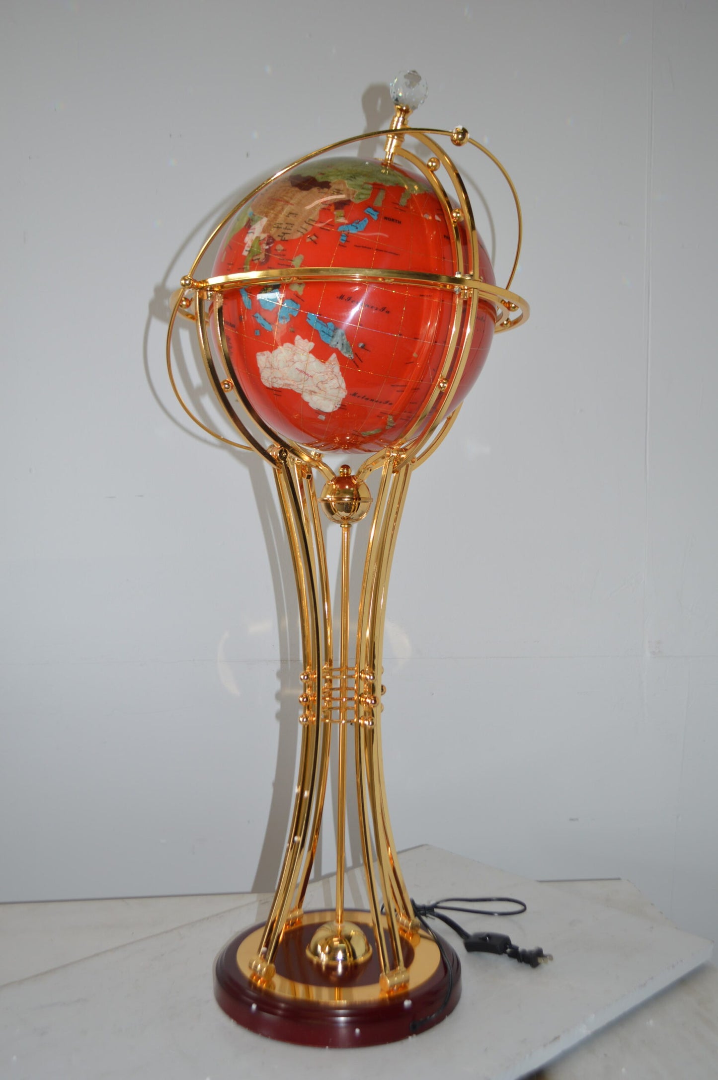 Illuminated Red - Gold World Globe Rotated by motor - Size: 19"L x 19"W x 42"H.