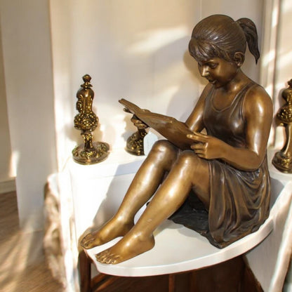 Girl Sitting and Reading a Book Bronze Statue -  Size: 23"L x 15"W x 24"H.