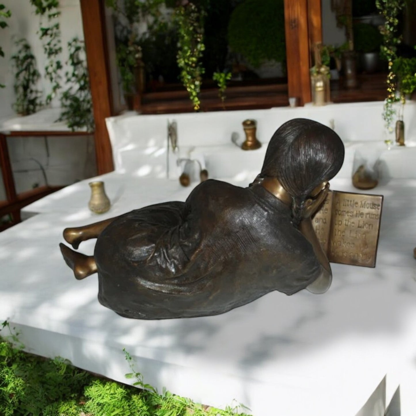 Girl laying reading a book Bronze Statue -  Size: 36"L x 17"W x 18"H.
